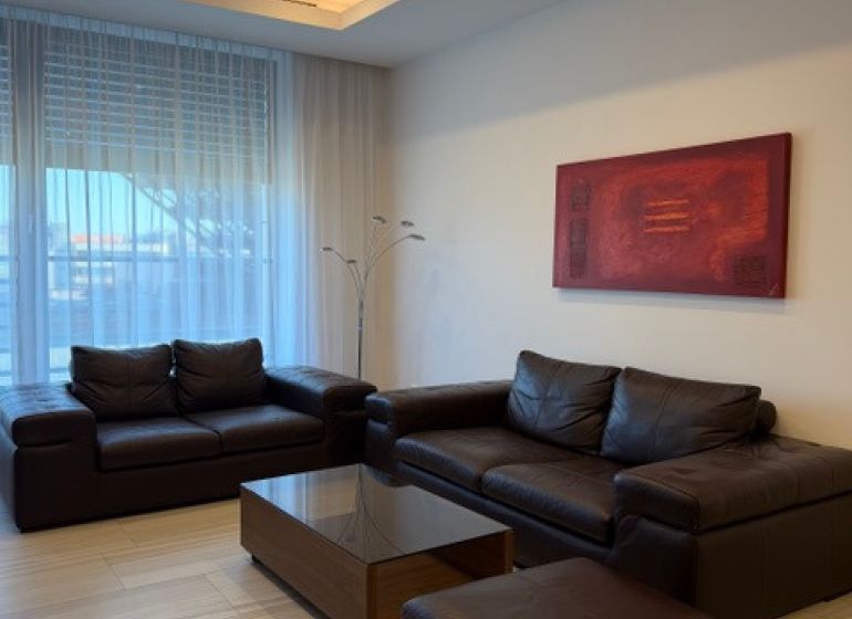 Ledersofa in einer 3-Zimmer-Wohnung mit Holzboden.