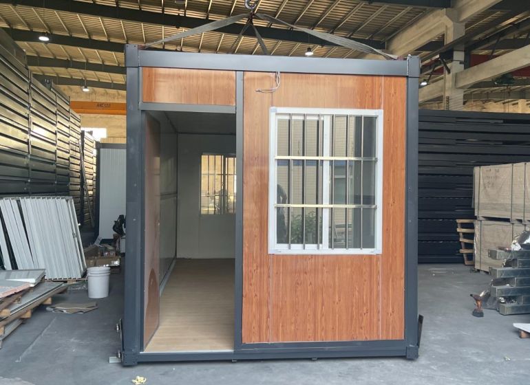 Containerhaus mit Holzboden im Inneren der Halle.