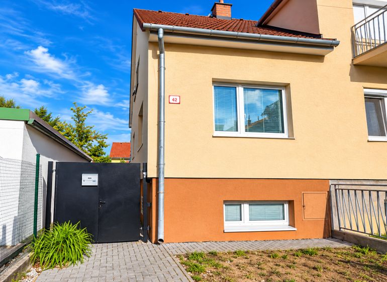 Einfamilienhaus in der Kupeckého-Straße in Piešťany mit eingezäuntem Hof und Eingangstor.