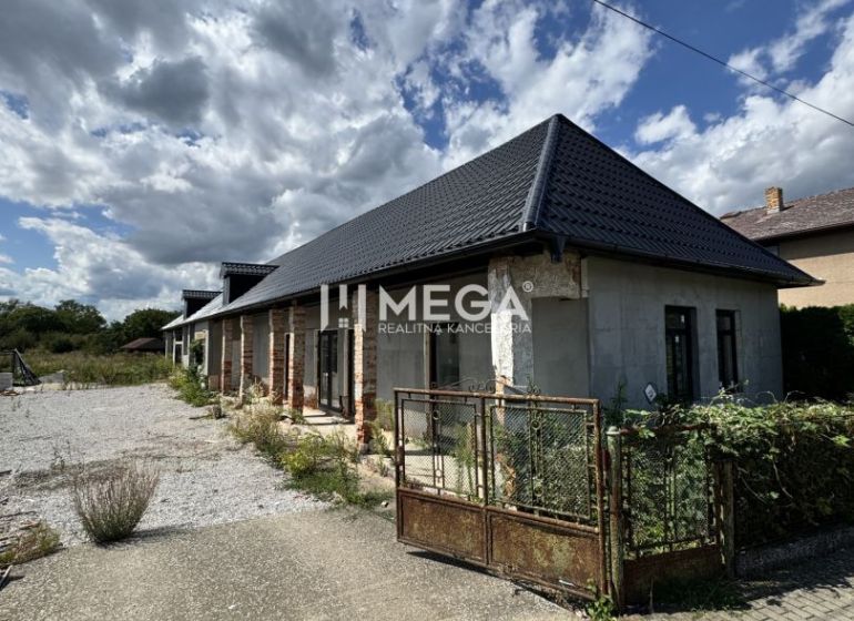 Ein Einfamilienhaus in Nacina Ves mit modernem Dach und einem weitläufigen offenen Grundstück.