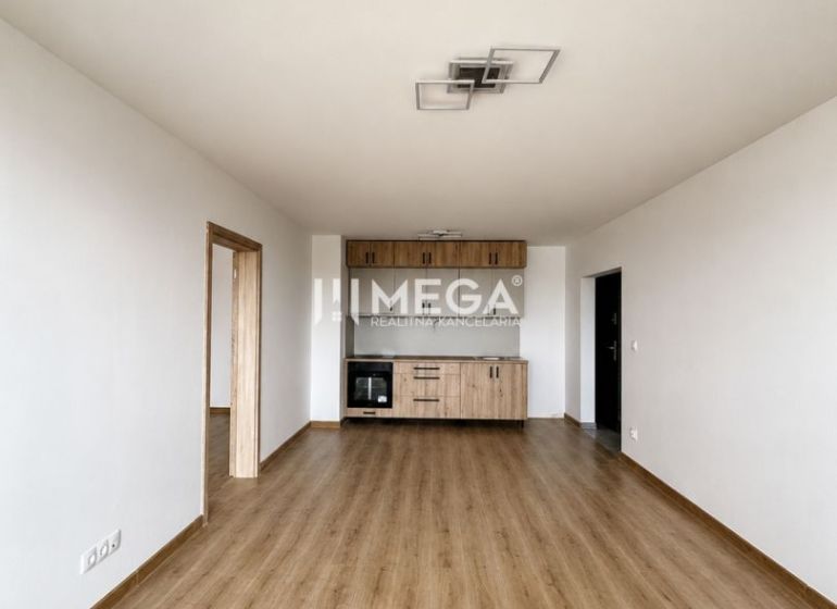 Wohnzimmer in einer 3-Zimmer-Wohnung mit Holzboden und Küchenzeile.