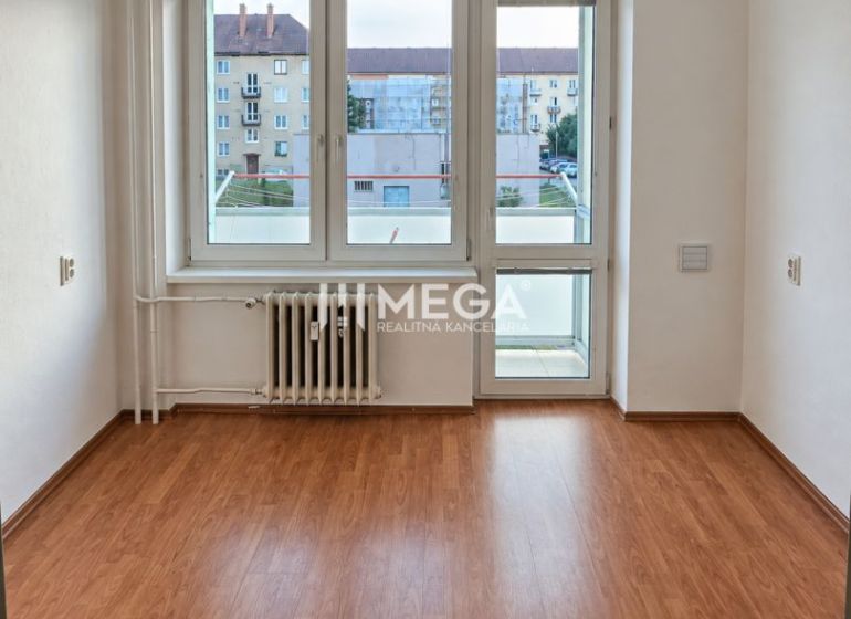 Ein Zimmer in einer 2-Zimmer-Wohnung mit einem Holzboden und einem großen Fenster.