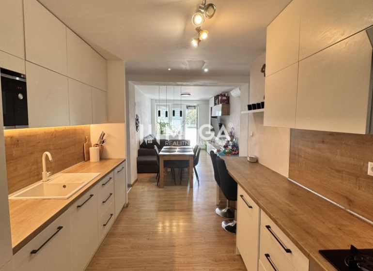 Küche in einer 3-Zimmer-Wohnung mit Holzboden und weißen Schränken.