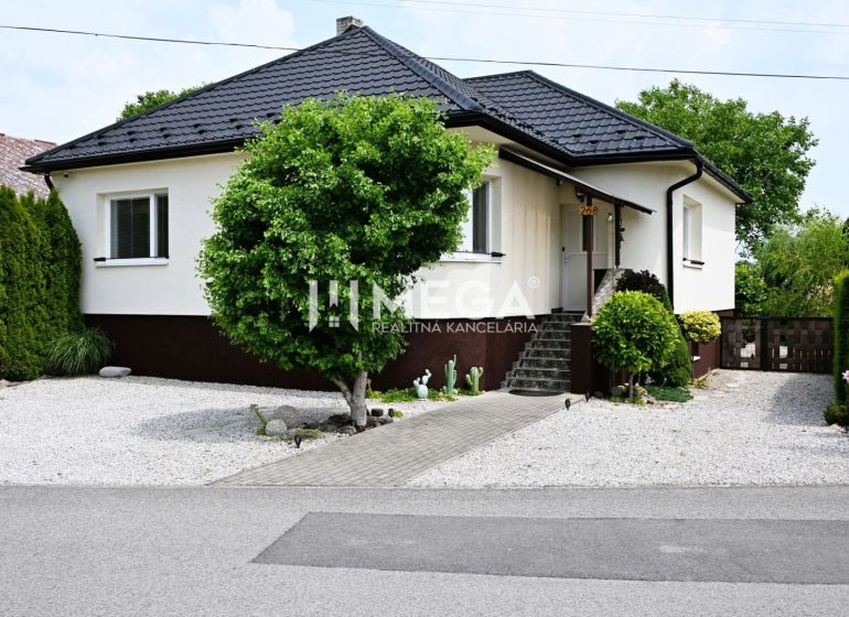 Ein Einfamilienhaus in Udavské mit einem gepflegten Garten, einem Gehweg und Ziersträuchern.