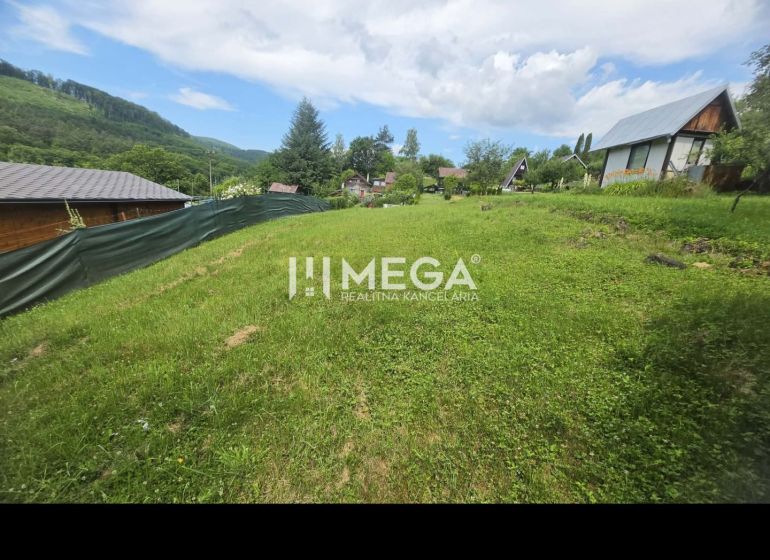 Gärten in Snina in Snina mit Rasen, Umzäunung und Blick auf die Berge im Hintergrund.