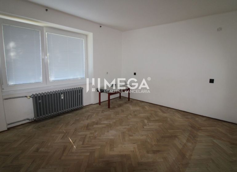 Ein Zimmer mit Holzboden und Heizkörper in einer 2-Zimmer-Wohnung.