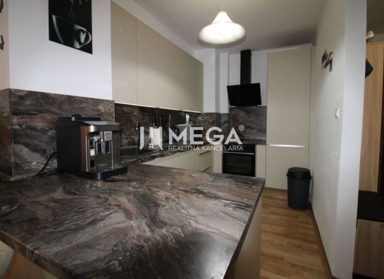 Küche in einer 2-Zimmer-Wohnung mit dunklem Marmordekor und Holzboden.