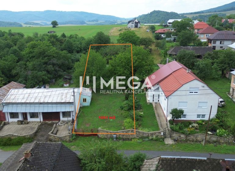 Grundstück in Oľšinkovo, geeignet zum Wohnen, umgeben von Grünflächen und nahegelegenen Häusern.