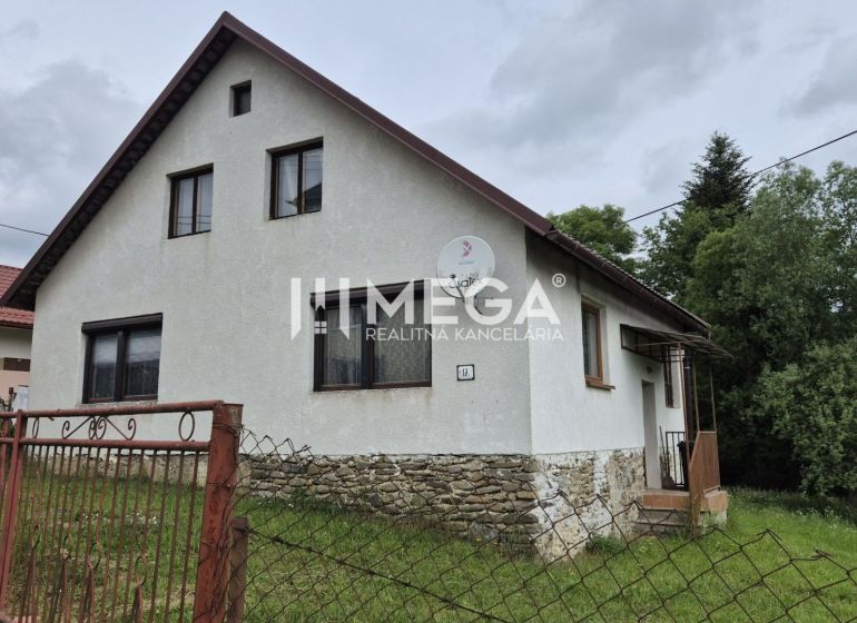 Ein Einfamilienhaus in Zboj mit einem Steinfundament und einem Garten, umgeben von Grün.