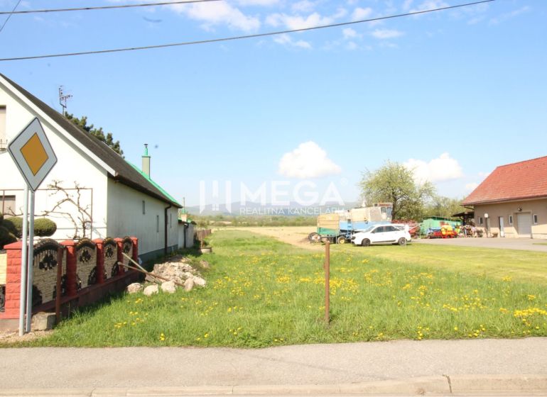Grundstücke - Wohnen in Sačurov mit Häusern, Rasen und Verkehrsschild.
