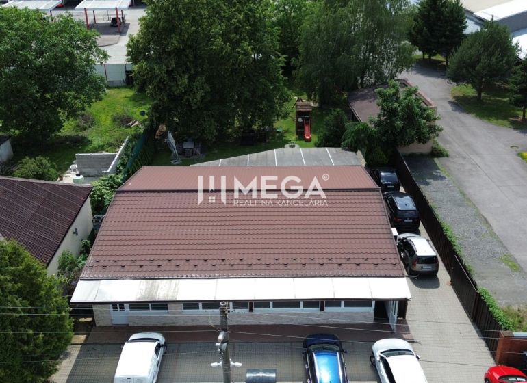 Gastronomische Räumlichkeiten in der Budovateľská-Straße in Vranov nad Topľou, umgeben von Autos und Grünflächen.