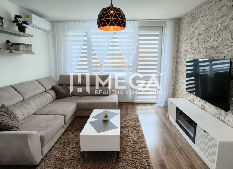 Wohnzimmer in einer 3-Zimmer-Wohnung mit einer Eckcouch und einem Boden in Holzoptik.