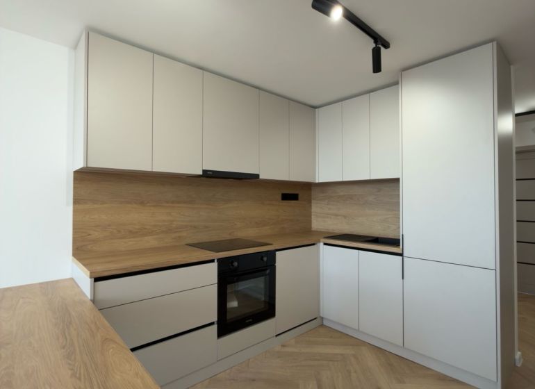 Küche in einer 4-Zimmer-Wohnung mit Holzboden und modernen Schränken.