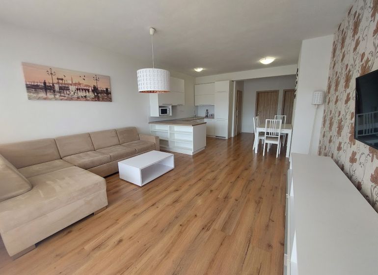 Wohnzimmer mit Holzboden und Ecksofa in einer 3-Zimmer-Wohnung.