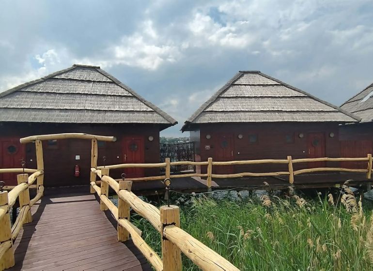 Holzhütten über dem Wasser mit Strohdächern bei den Seen von Senec.