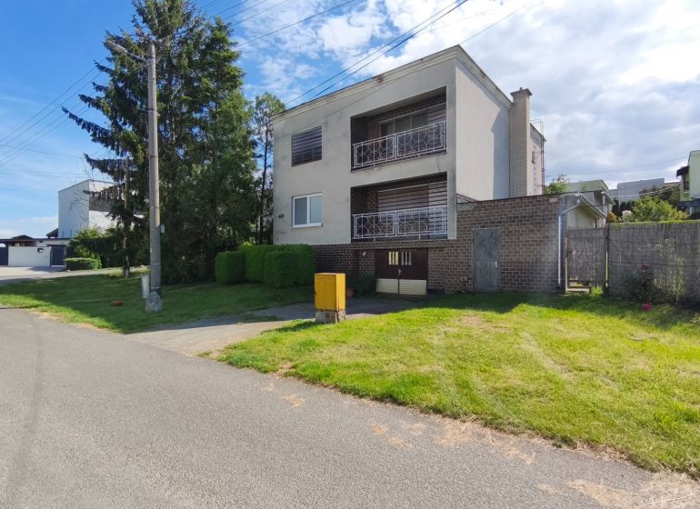 Ein Einfamilienhaus in Nenince mit Garten, Garage und Balkon in einer ruhigen Straße.