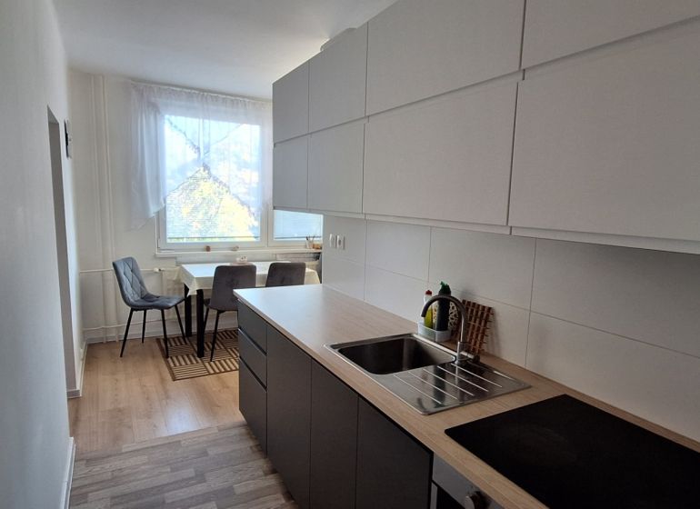 Küche in einer 3-Zimmer-Wohnung, mit Holzboden und Essecke.