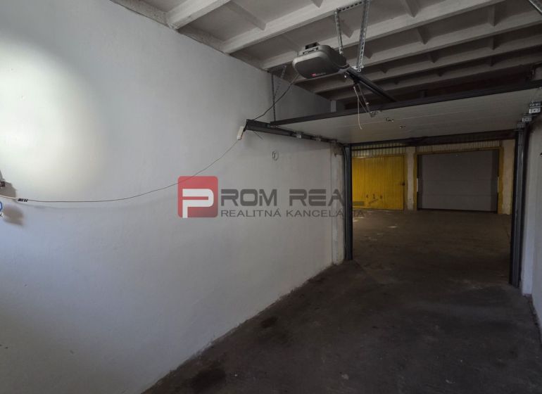 Die Garage hat weiße Wände und einen Mechanismus für das Tor.