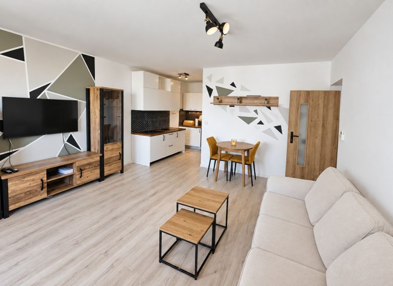 Wohnzimmer mit Küchenzeile und Holzboden in einer 2-Zimmer-Wohnung.