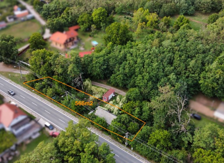Luftaufnahme eines Grundstücks mit einer Hütte in Šaštín-Stráže neben Einfamilienhäusern.