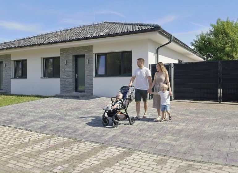 Ein Einfamilienhaus in Hôrka nad Váhom mit einer Familie auf der gepflasterten Zufahrt.
