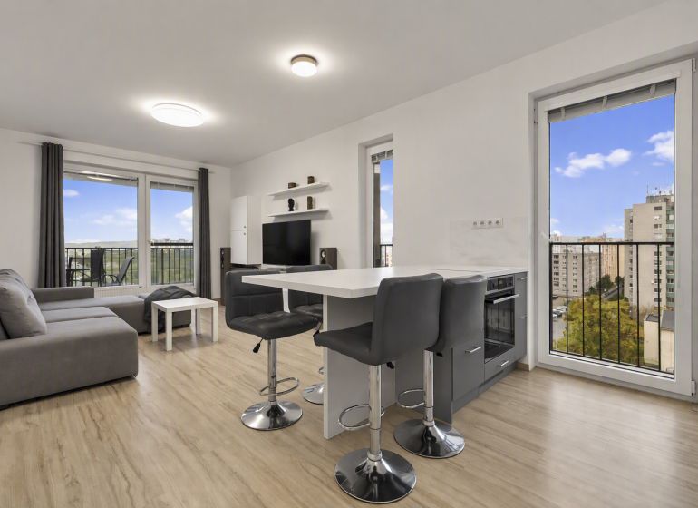 Wohnzimmer mit Küchenzeile und Holzboden in einer 2-Zimmer-Wohnung.