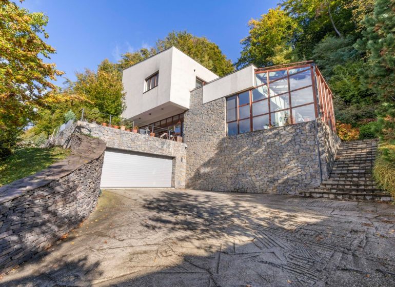 Ein Einfamilienhaus in der Karpatská-Straße in Marianka, umgeben von Grün mit einer verglasten Terrasse.