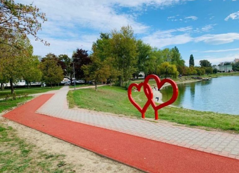 Der Gehweg entlang des Sees mit roten Herzen in Bratislava - Ružinov, Trebišovská.