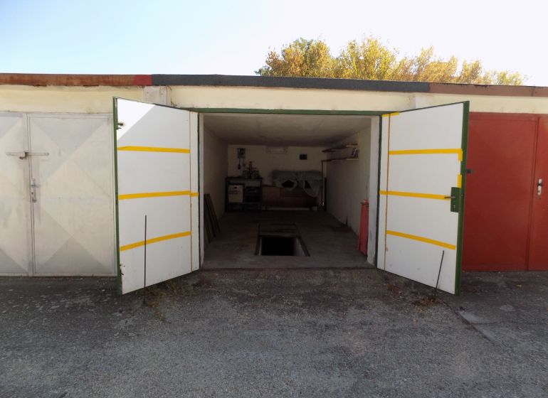 Offene Garage in der Petőfi-Reihe in Štúrovo mit Grube und gelagerten Gegenständen.