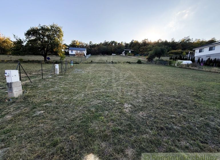 Gärten in Krupina, Häuser am Hang, Gras und Bäume, man sieht einen Verteilerkasten.