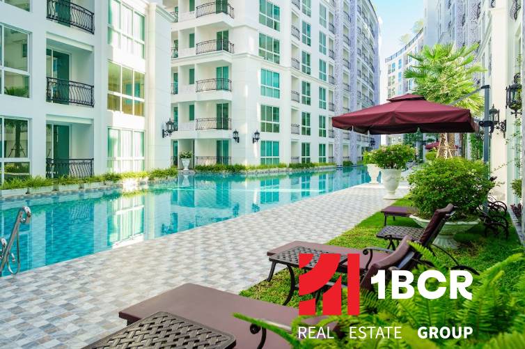 Pattaya, Bau von Wohnungen mit Pool, Liegestühlen und Sonnenschirmen in einem Wohngebiet.