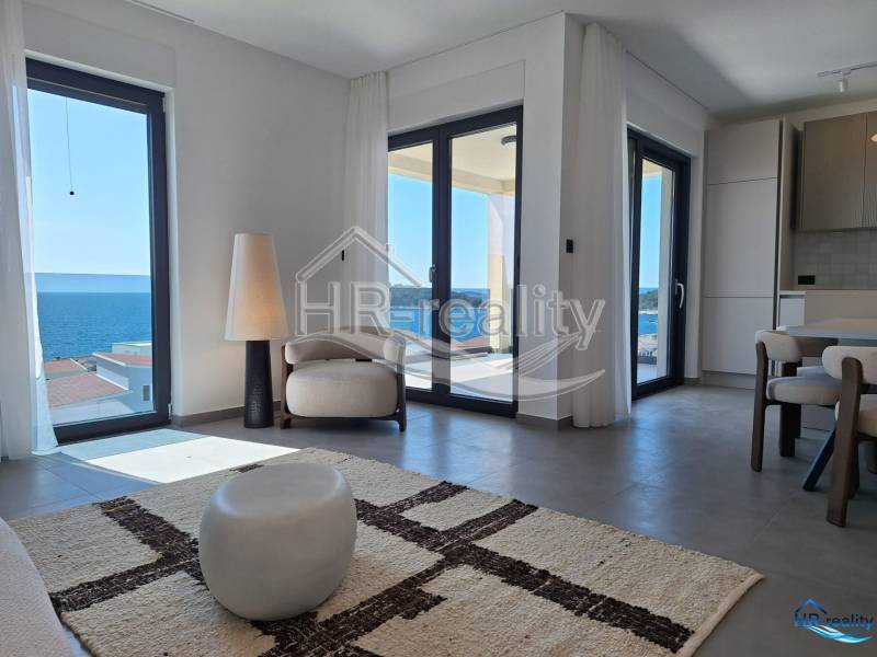 Helles Interieur einer Ferienwohnung mit Meerblick und bequemer Sitzecke.