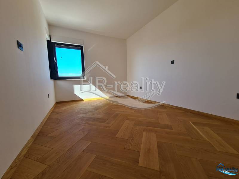 Ein Raum mit Holzboden und einem großen Fenster in einer Ferienwohnung.