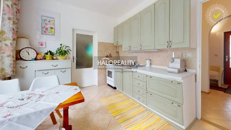 Helle Küche mit Schränken, Esstisch und Dekorationen in einer 4-Zimmer-Wohnung.