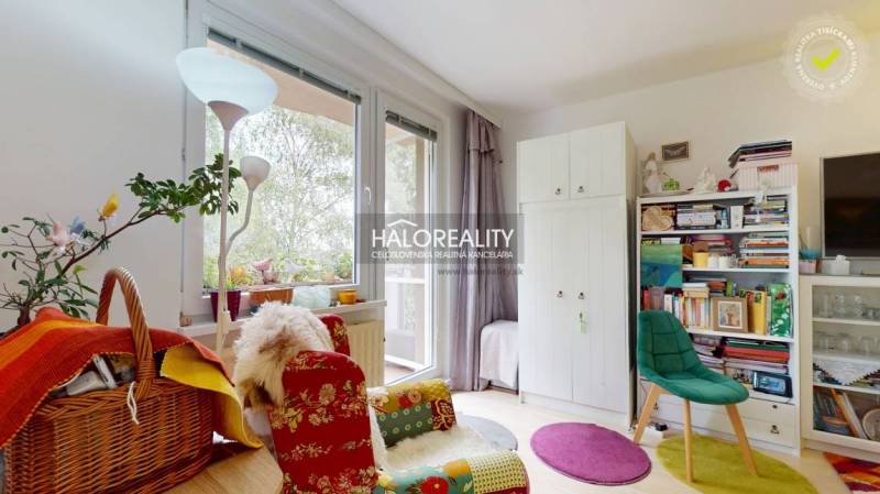 Ein farbenfrohes Interieur einer 4-Zimmer-Wohnung mit Büchern und einem bequemen Sessel am Fenster.