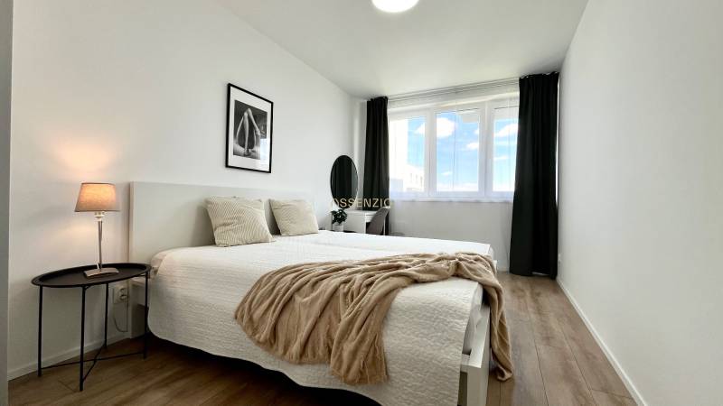 Helles Schlafzimmer in einer 2-Zimmer-Wohnung mit zwei Betten und einem Fenster.