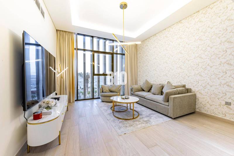 Wohnzimmer in einer 3-Zimmer-Wohnung mit großen Fenstern, Sofa und Fernseher auf Holzboden.