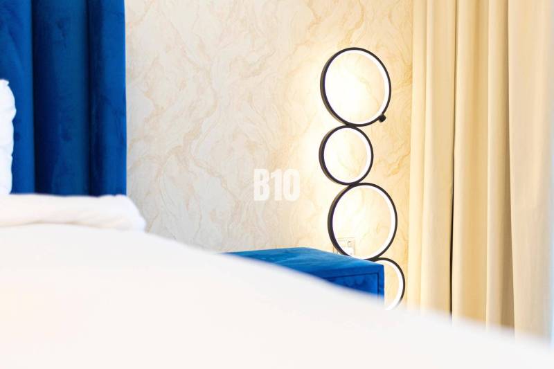 Wandleuchte mit runden Rahmen bei den Vorhängen in einer 3-Zimmer-Wohnung.