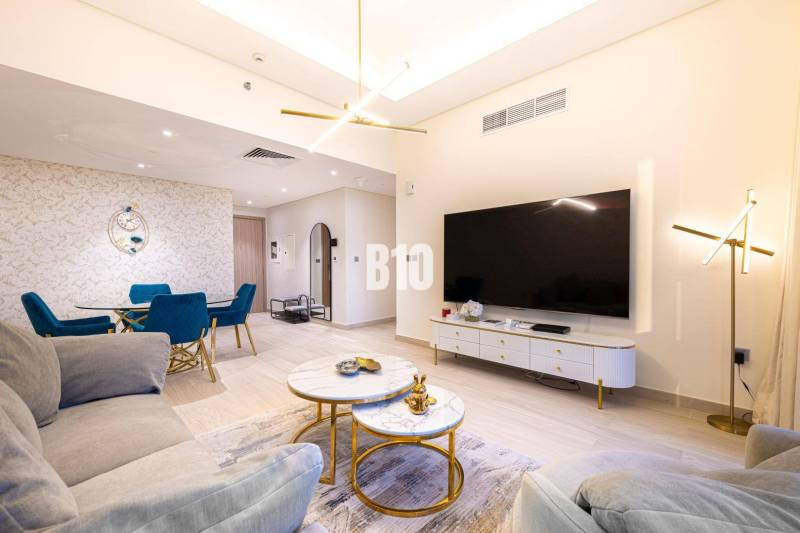 Wohnzimmer in einer 3-Zimmer-Wohnung mit Sofa, Fernseher und Esstisch.