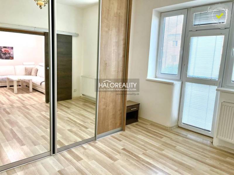 3-Zimmer-Wohnung mit Laminatboden, großem Spiegel und weißen Wänden.