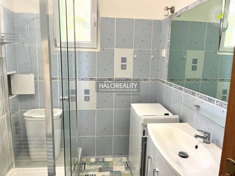 Badezimmer in einer 3-Zimmer-Wohnung mit Dusche, Waschmaschine und Waschbecken.