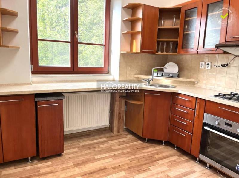 Küche in einer 3-Zimmer-Wohnung mit Holzküche, Fenster mit Blick ins Grüne.