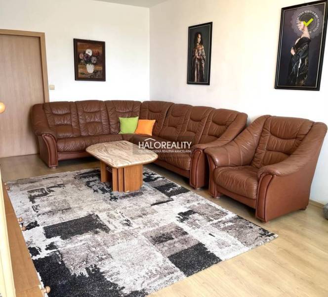 Ledersofa im Wohnzimmer einer 3-Zimmer-Wohnung. An der Wand hängen Bilder.