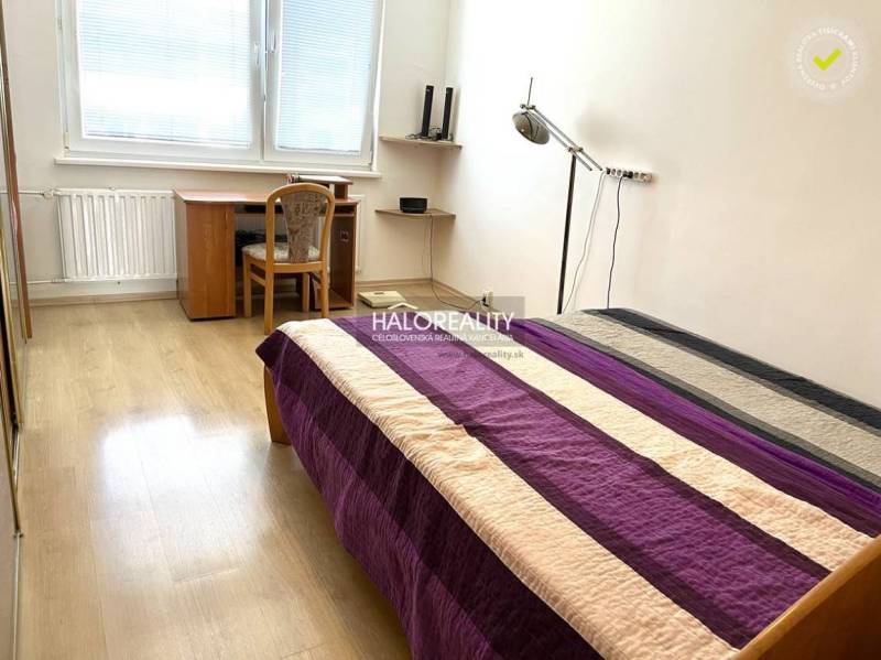 Schlafzimmer in einer 3-Zimmer-Wohnung mit Bett, Schreibtisch und Holzboden.