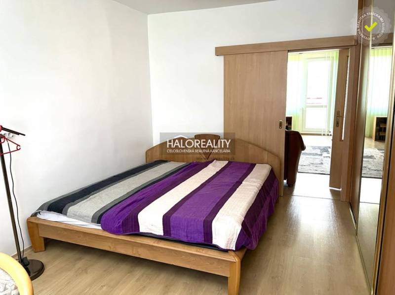 Schlafzimmer in einer 3-Zimmer-Wohnung mit einem Holzbett und Einbauschränken.