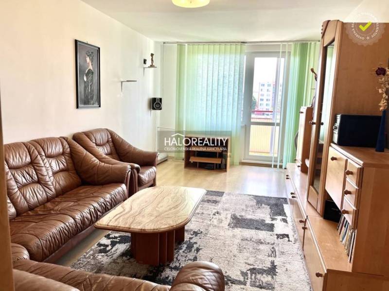 Wohnzimmer in einer 3-Zimmer-Wohnung mit einem braunen Sofa und Holzmöbeln.