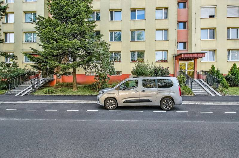 Landauova Straße in Bratislava-Dúbravka mit einem Wohngebäude und einem davor geparkten Auto.