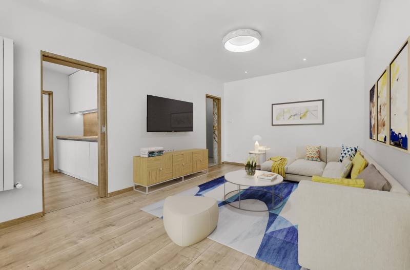 Wohnzimmer mit Sofa, Bildern und Fernseher in einer 4-Zimmer-Wohnung.