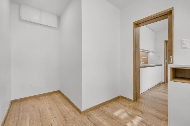 Einrichtung in einer 4-Zimmer-Wohnung mit Holzboden und Übergang zur Küche.