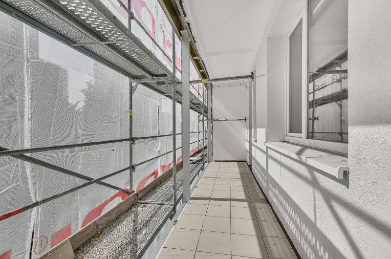 Balkon einer 4-Zimmer-Wohnung in Renovierung mit Gerüst und Fliesen.